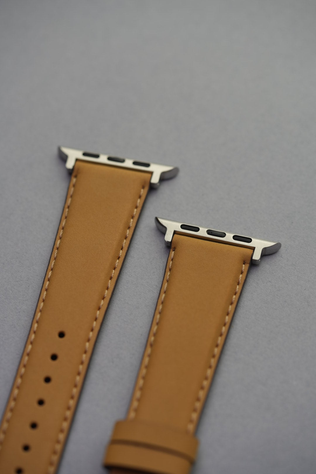 Mustardnubuck leather Apple Watch strap with adapters, laid flat to show full strap profile.