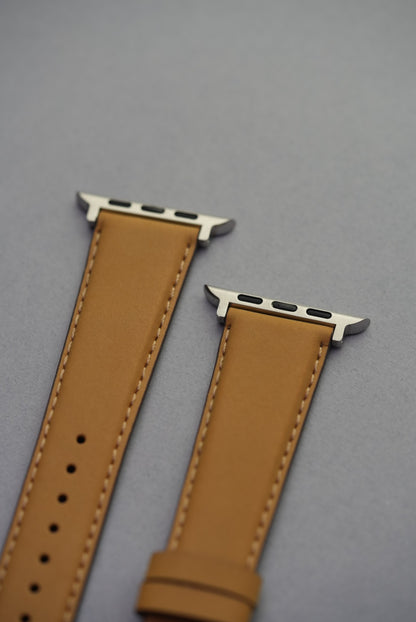 Mustardnubuck leather Apple Watch strap with adapters, laid flat to show full strap profile.