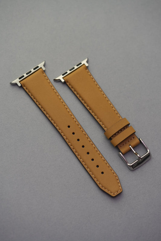 mustard nubuck leather Apple Watch strap with adapters, laid flat to show full strap profile.