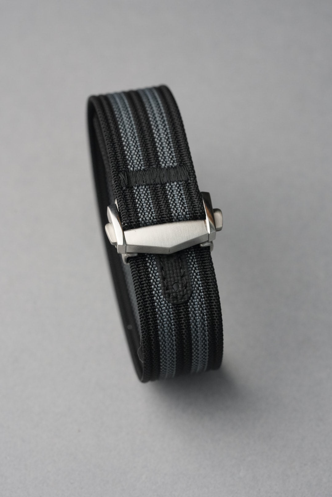 MoonSwatch nylon deployant strap — buckle end and strap keeper detail, brushed steel hardware