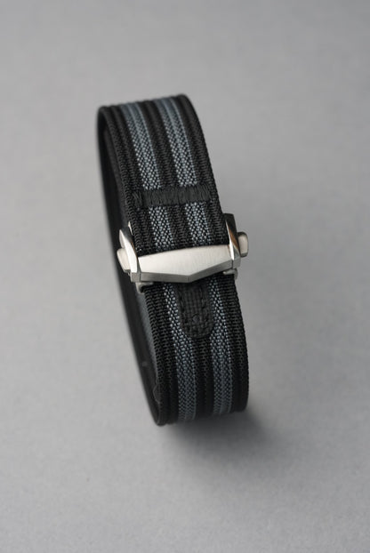 MoonSwatch nylon deployant strap — buckle end and strap keeper detail, brushed steel hardware