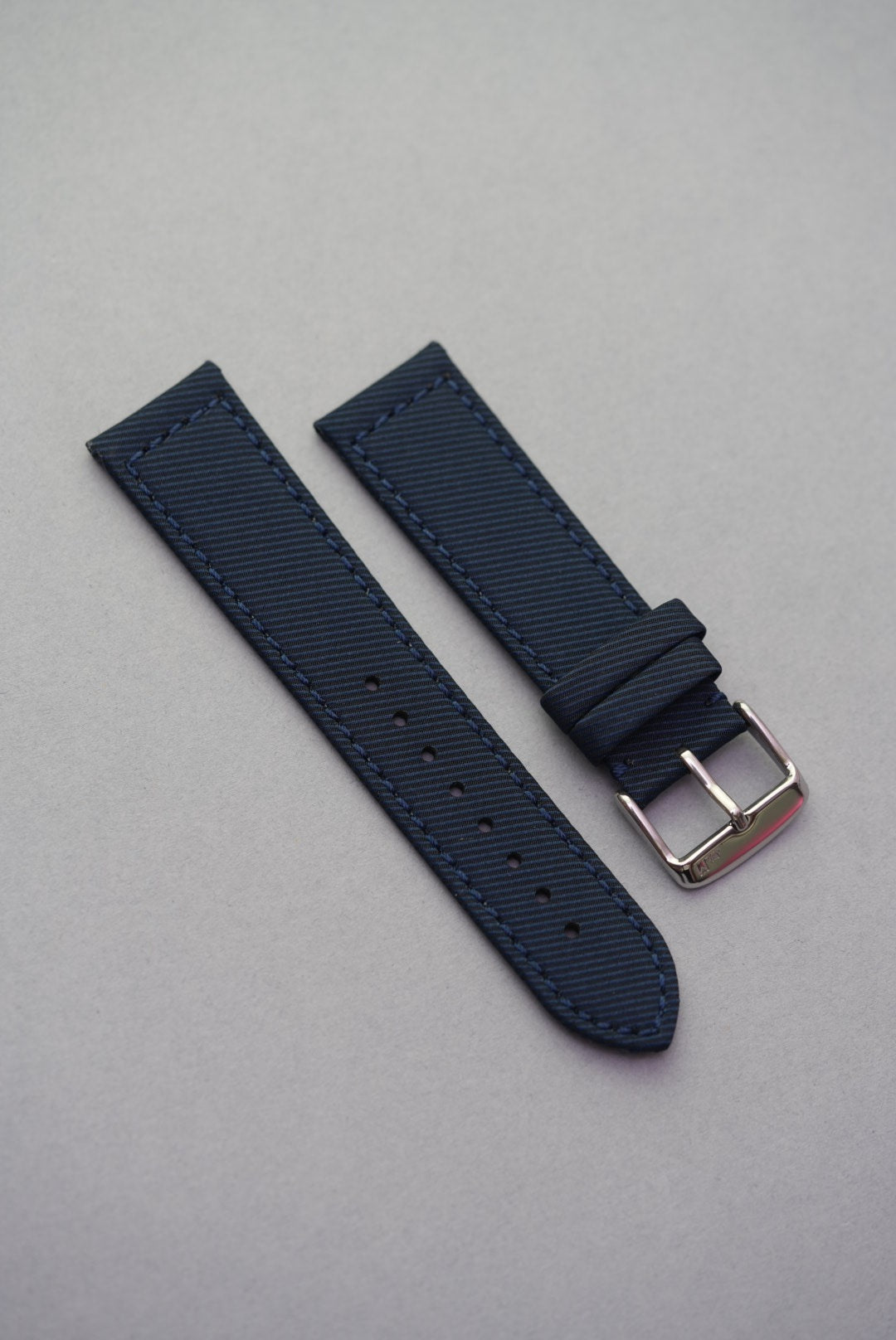 Deep ocean blue gabardine recycled watch strap with fitted buckle and stitched edges, offering a soft matte grain and smart profile.