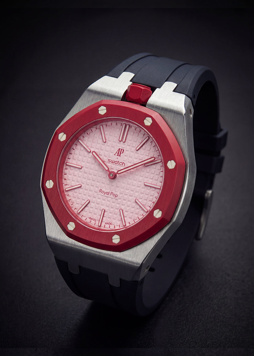 Watch with red face and silver case on a dark background