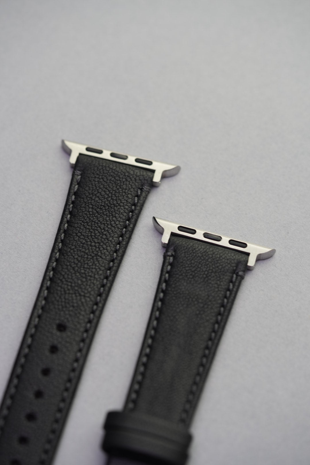Angled close-up of Piano Noir strap paired with Apple Watch, highlighting grain texture and stitching.