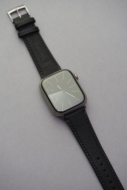 Piano Noir sheepskin strap fitted to Apple Watch, featuring rich matte black leather with tonal stitching.