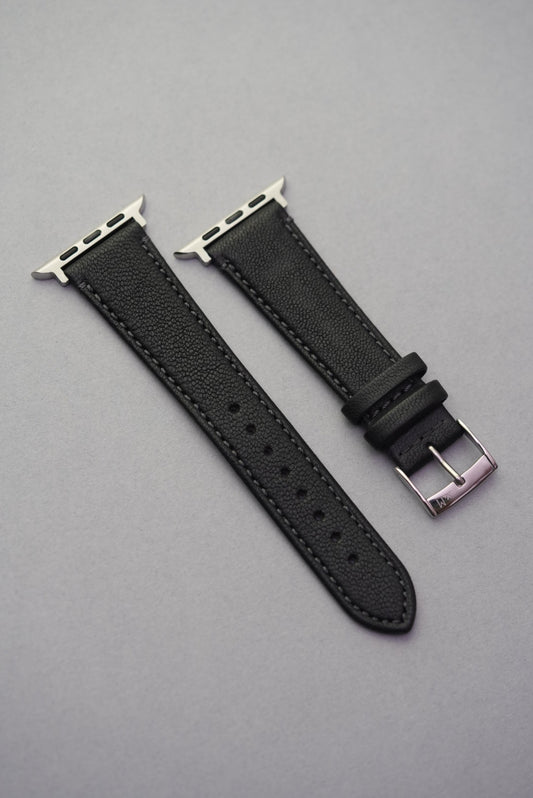 Full-length view of the Piano Noir Apple Watch strap in fine-grain sheepskin with polished buckle and adaptors.