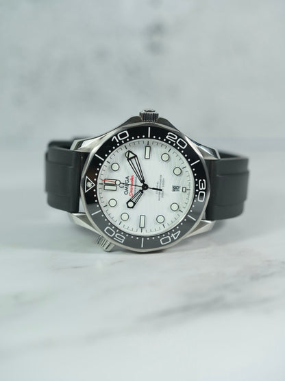 Front view of an Omega Seamaster watch with a black FKM rubber strap, showcasing its sleek design on a marble background.