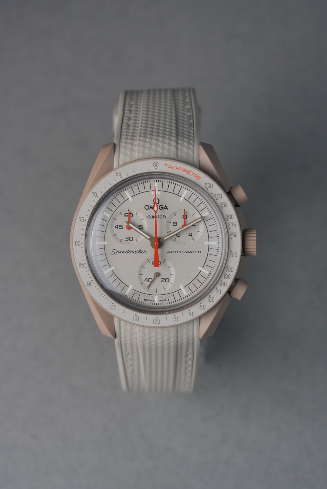  Beige rubber woven MoonSwatch strap with matching stitching and curved fit for a subtle, neutral aesthetic.