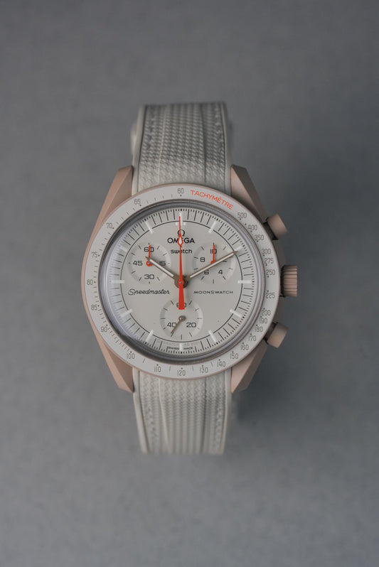  Beige rubber woven MoonSwatch strap with matching stitching and curved fit for a subtle, neutral aesthetic.