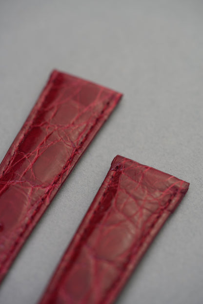 Detailed view of the top ends of the ruby red crocodile strap, highlighting the fine stitching and exotic leather texture.