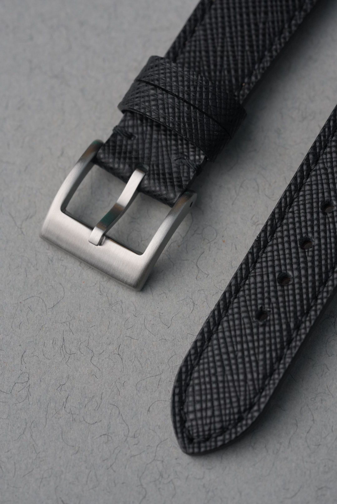 Polished stainless steel buckle on black Saffiano leather strap