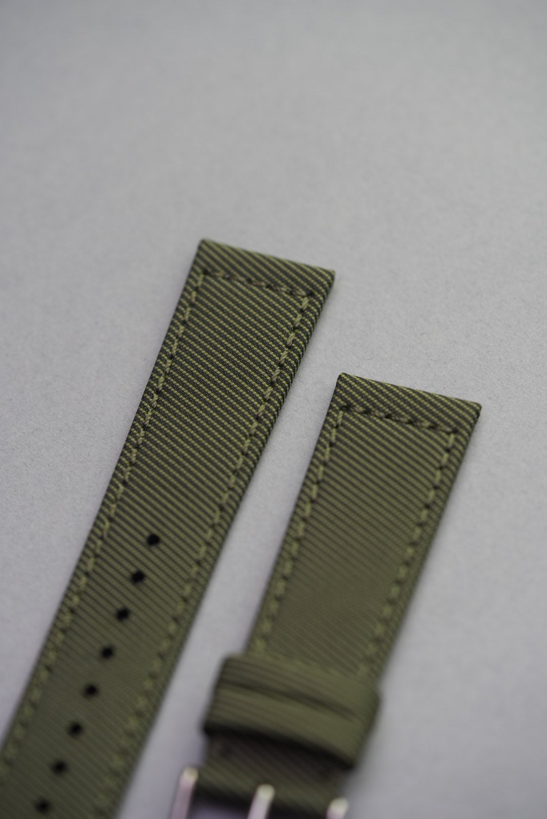 Detail image of the Sagebrush strap highlighting the remborded edge and uniform tonal stitching in muted green thread.
