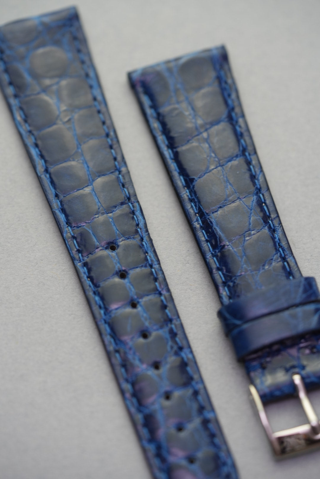 Sapphire blue crocodile leather strap for Cartier laid flat, showcasing rich grain and vibrant tonal depth.
