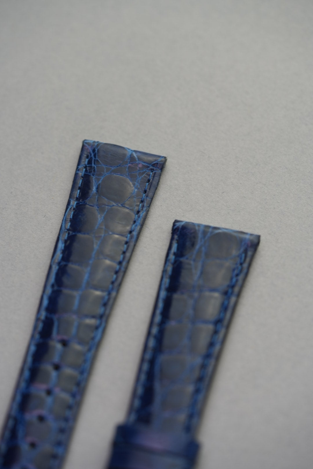 Close-up of strap ends on the sapphire crocodile leather strap, showing even stitching and natural scale variation.