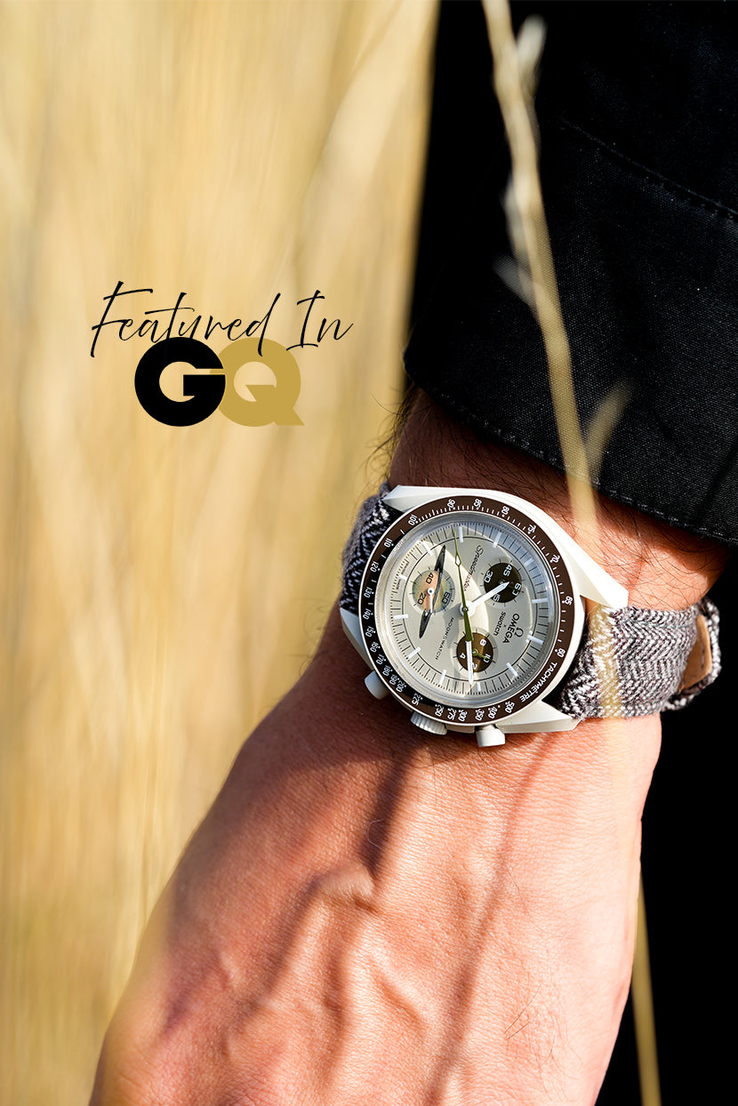 Close-up of a wrist wearing a silver watch with a blurred background