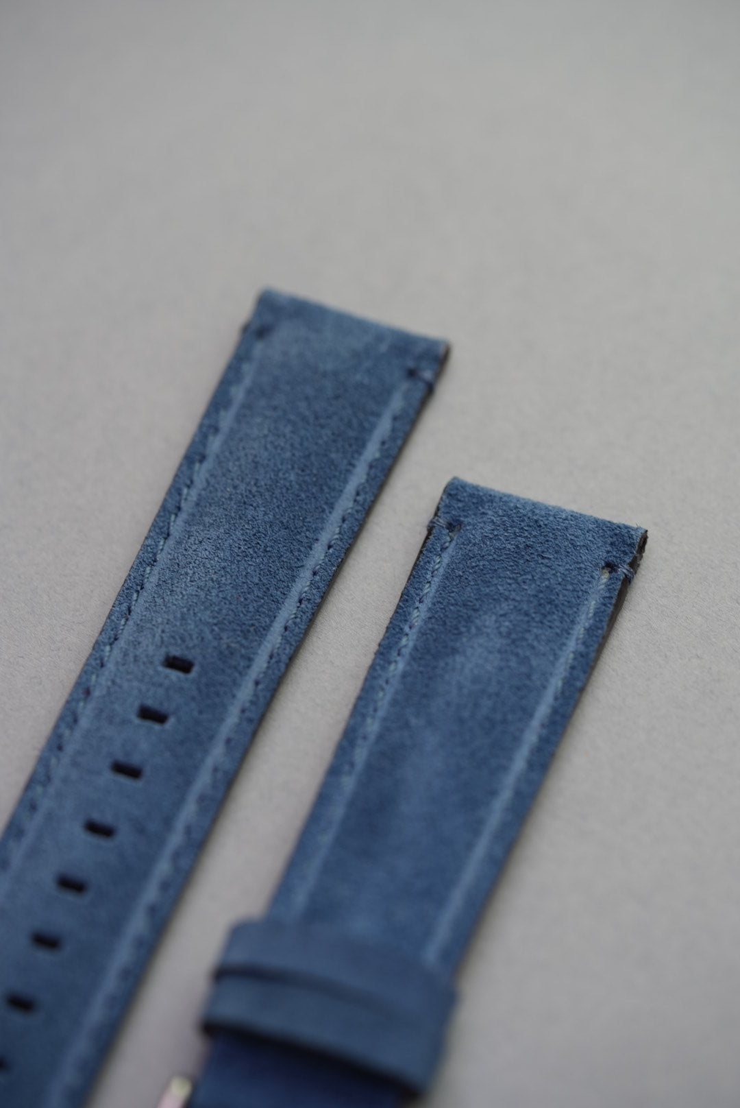 Macro close-up of blue suede finish and clean stitching on leather watch strap