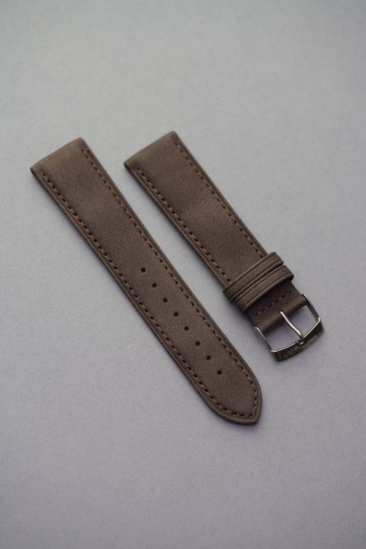 Dark brown suede watch strap laid flat showing clean stitching and buckle.