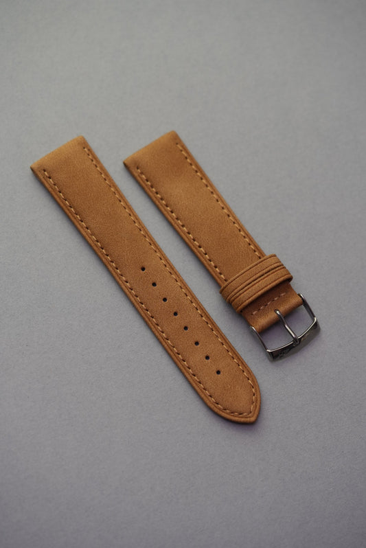 Dark brown suede watch strap laid flat showing clean stitching and buckle.