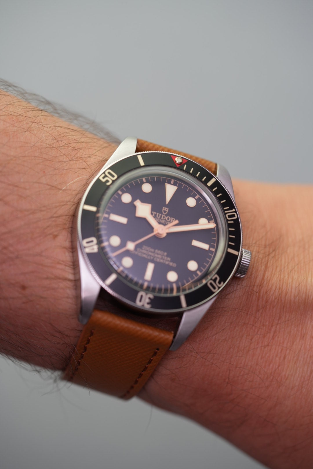 Wrist shot of a Tudor dive watch paired with the tan Saffiano leather strap, showing real-life fit and texture.