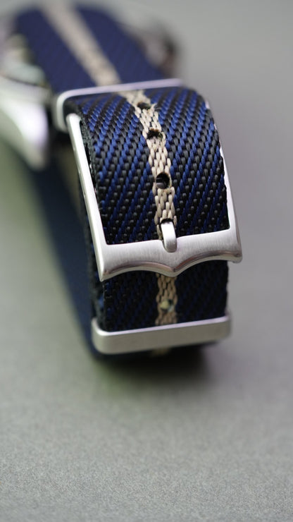 Macro view of woven texture showing black, blue, and cream stripe detail on nylon strap fitted to Tudor Black Bay.