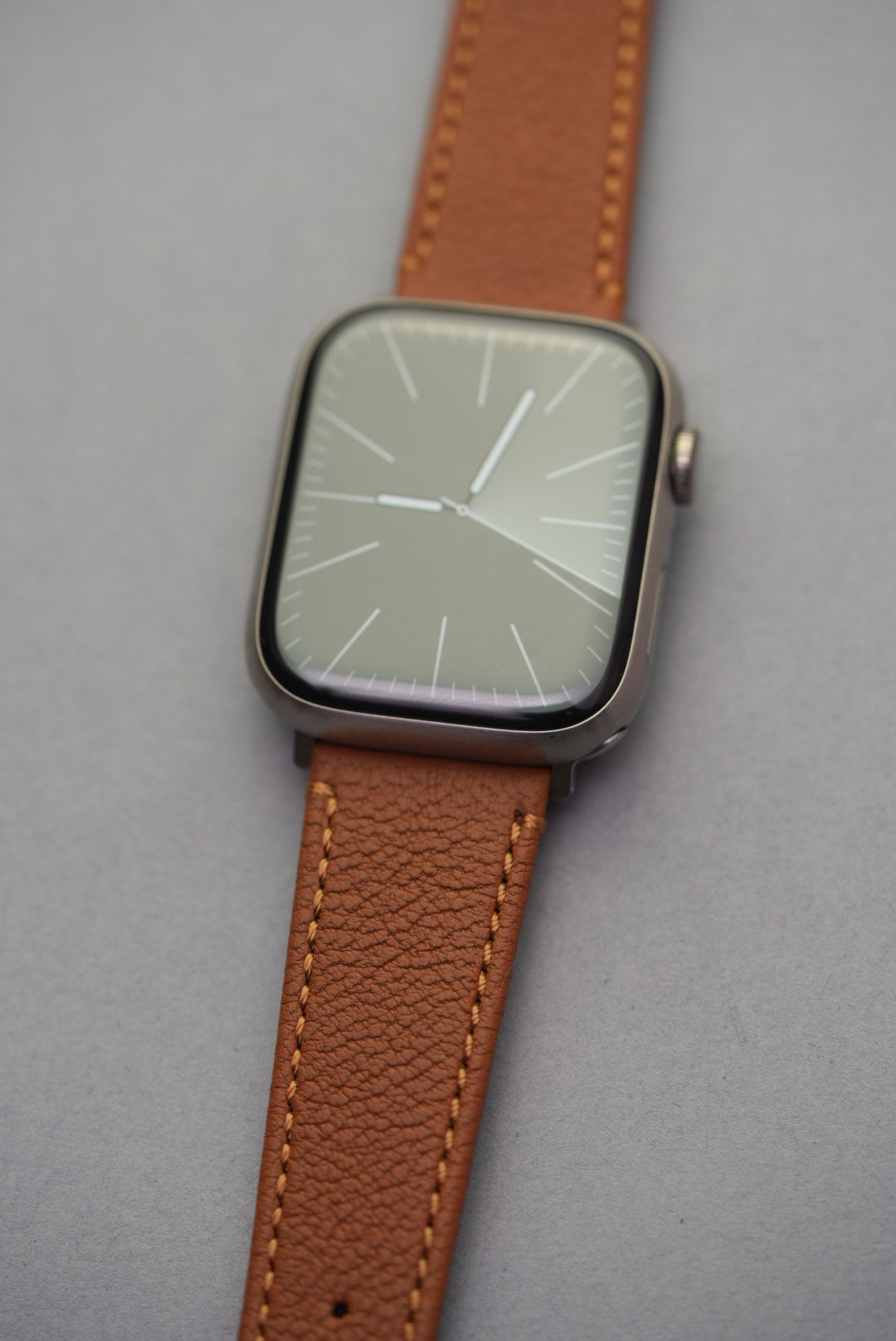 Angled close-up of Apple Watch fitted with Tuscan Sand sheepskin strap, highlighting grain texture and soft structure.